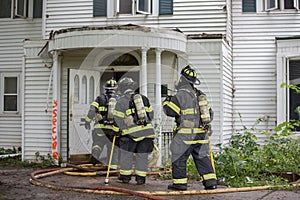 Three Firefighters on Fire Scene Walking into a building