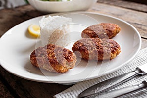 Three fish cutlet on white plate with rice