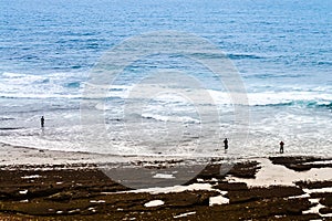 Three fishermen fishing from the sea