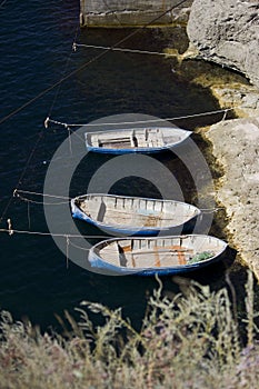 Three fishing boats aerial view are tied to the shore near the fishing enterprise. mooring with boats