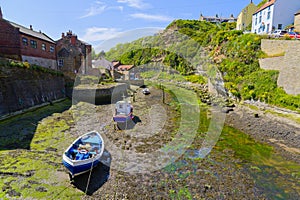 Three fishing boats sitting on the bed of Staithes Beck in Staithes