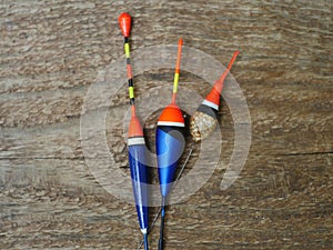 Three fishing bobbers on wooden background