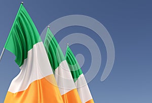 Three flags of Ireland on flagpole on blue background. Place for text. The flag is unfurling in wind. Dublin. Europe, Irish. 3D