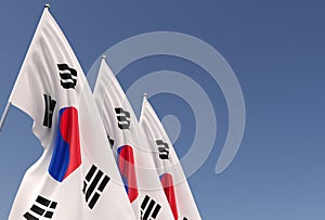 Three flags of South Korea on a flagpole on a blue background. Place for text. The flag is unfurling in wind. Korean. Asia, Seoul