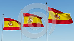 Three flags of Spain against blue sky.