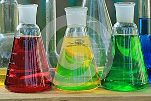 Three flasks with colored liquid reagents.