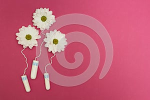 Three flowers from hygienic tampons on a pink background
