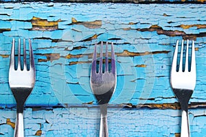 Three forks on blue wooden background