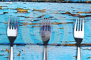 Three forks on blue wooden background