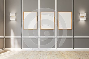 Three framed posters on gray wall