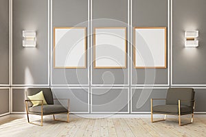 Three framed posters on gray wall, armchairs