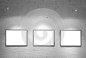 Three frames on brick white wall