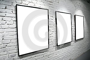 Three frames on brick white wall