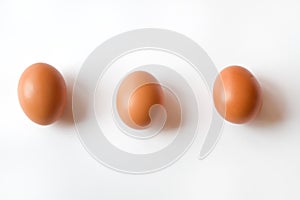 Three Fresh Organic Brown Eggs isolated on a White Background