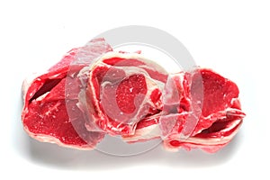 Three fresh raw lamb loin chops on a white background, isolated.
