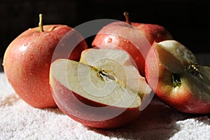 Three fresh red apples and one of them split by half