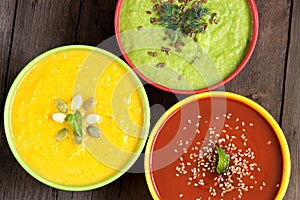 Three fresh soups on a wooden table