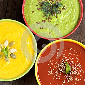 Three fresh soups on a wooden table