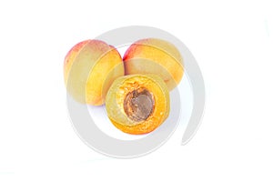 Three fresh sweet apricot fruit, whole and half, group of juicy ripe apricots closeup, isolated on the white background