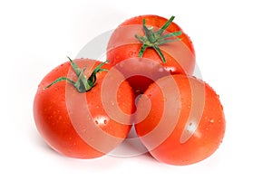 Three fresh tomatoes with green leaves isolated on white background