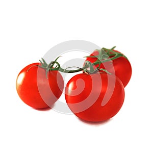 Three fresh tomatoes with green leaves isolated on white background. red ripe heirloom tomatoes