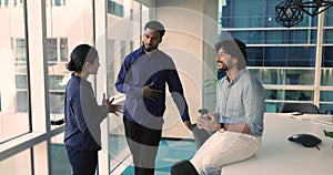 Three friendly teammates talking met in conference room