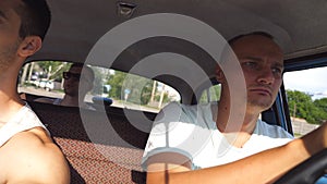 Three friends drives in vintage automobile at country road. Young guy sitting at the front seat of retro car and