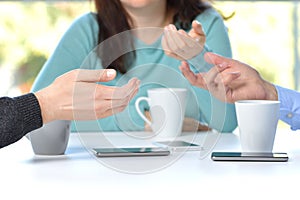 Three friends hands talking in a bar with phone on the table