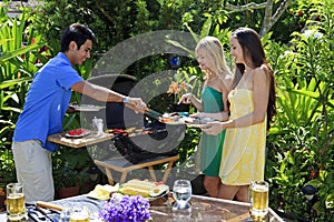 Three friends having a barbecue lunch