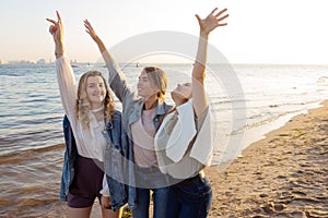Three friends having fun on the beach, meeting friends. Young women