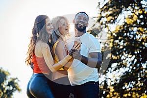 Three friends having fun dancing kizomba on a meadow