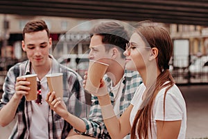 Three Friends Having Hot Drinks outdoors In Plastic Cups Outdoor.