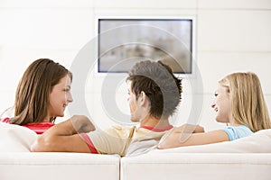 Three friends in living room watching television