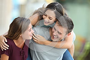 Three friends meeting and joking on the street