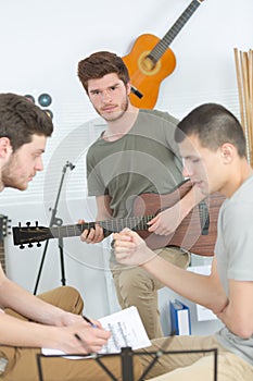 three friends playing instruments at home