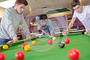 three friends playing pool