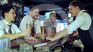 Three friends sitting at the bar and keep the beer