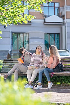 Three friends sitting on a bench near the house