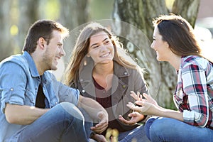 Three friends talking sitting in a park
