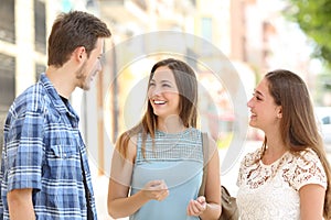 Three friends talking taking a conversation on the street photo