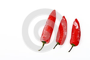 Three frozen red chilli peppers