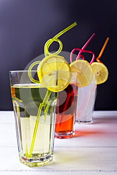 Three fruits soft-drinks with tubules lemon on a edge of a glass. Lime a