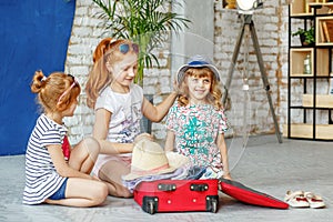 Three fun children pack a suitcase for a beach holiday. Concept, lifestyle, childhood, trip, vacation, family tourism