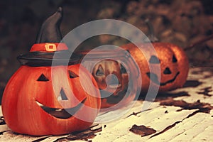 Three funny Halloween pumpkins on wood desk. Autumn mood photo