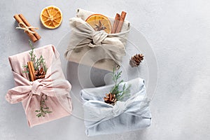 Three furoshiki style wrapped gifts with natural decor. Zero waste.
