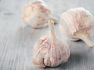 Three garlic bulb close up on gray wooden table