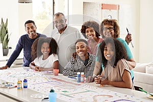 Three generation African American  family making a sign for surprise party smiling to camera,close up