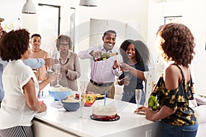Three generation African American  family raising glasses to make a toast during a celebration at home