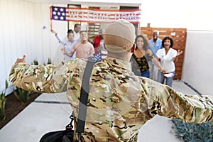 Three generation African American  family welcoming millennial soldier returning home,back view, focus on foreground