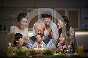 Three generation asian family celebrating grandpa`s birthday at home